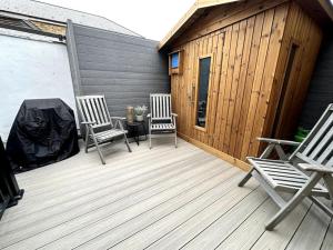 Duas cadeiras e uma mesa num deque de madeira em Central Margate house with sauna & private garden em Kent