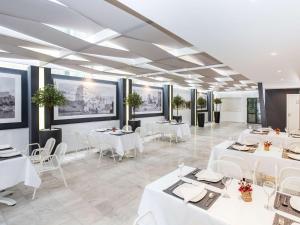 a dining room with white tables and white chairs at Mercure Rhodes Alexia Hotel & Spa in Rhodes Town