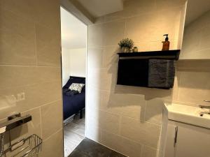 uma casa de banho com um lavatório e uma cama num quarto em Central Margate house with sauna & private garden em Kent