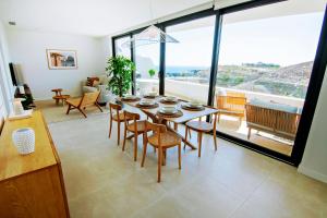 Un comedor con mesa y sillas y una gran ventana. en Mara's Apartments Higuerón West - Nordic Style - Sunny Terrace, en Fuengirola