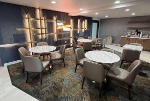 La Quinta Inn & Suites by Wyndham Yakima Downtown في ياكيما: غرفة انتظار مع طاولات وكراسي في مطعم