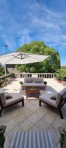 a patio with two couches and a white umbrella at Apartment Eufemia in Kanfanar