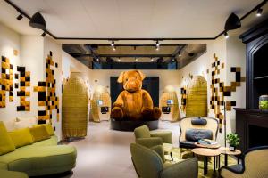 un grand ours en peluche assis au milieu d'une pièce dans l'établissement FirstName Bordeaux by Hyatt, à Bordeaux