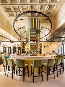 un restaurant avec un grand bar entouré de chaises dans l'établissement FirstName Bordeaux by Hyatt, à Bordeaux