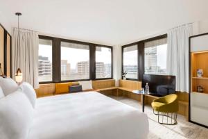 a hotel room with a large white bed and windows at FirstName Bordeaux by Hyatt in Bordeaux