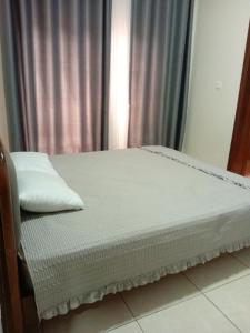 a bed sitting in a room with a window at KIM UNIVERSITY TWO ROOMS APARTMENT in Kigali