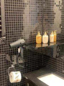 a bathroom with three soap dispensers and a sink at Romantic House -Romantyczny Domek dla 2 dorosłych in Gdynia