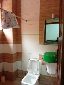 a bathroom with a toilet with a green lid at KIM UNIVERSITY TWO ROOMS APARTMENT in Kigali