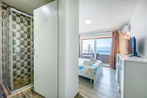 a bathroom with a shower and a bed with a window at Villa Tesla in Ohrid