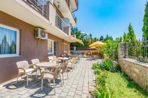 a patio with tables and chairs next to a building at Villa Tesla in Ohrid