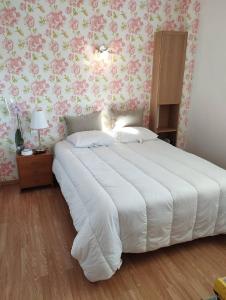 um quarto com uma cama grande e papel de parede floral cor-de-rosa em AS24540- P2 neuf à 100m de la Plage em Le Grau-du-Roi