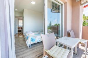 a room with a bed and a table and a window at Villa Tesla in Ohrid