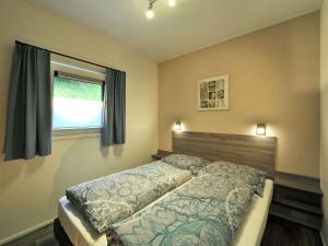 a bedroom with a bed and a window at Chalet in the Seeblick campsite in Kramsach in Kramsach