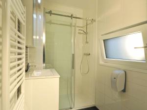 a bathroom with a shower and a tv on the wall at Chalet in the Seeblick campsite in Kramsach in Kramsach