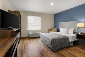 a bedroom with a bed and a flat screen tv at WoodSpring Suites Bowling Green I-65 in Bowling Green