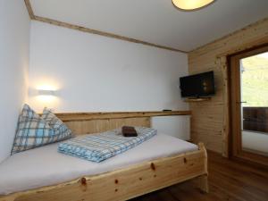 1 dormitorio con 1 cama y TV en una habitación en unique large alpine pasture in the middle of the Zillertal mountains, en Zellberg