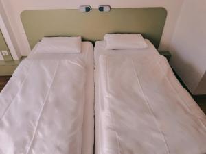 duas camas sentadas uma ao lado da outra num quarto em ibis budget Berlin Ost em Berlim