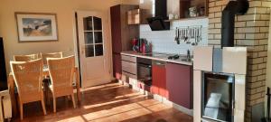 a kitchen with a stove and a table with chairs at Haus Seebrise in Wustrow +8 photos