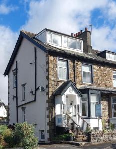 a white and brown brick house with a window at Invergarry Room Only Guest House For Adults in Windermere