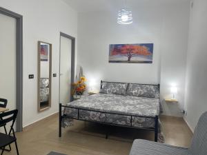 a bedroom with a bed and a painting on the wall at La Casuzza del Borgo in Agrigento