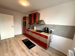 a kitchen with red cabinets and a wooden floor at Soleblick 