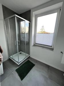 uma casa de banho com um chuveiro e uma janela grande em Soleblick 