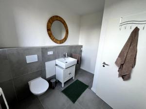 W łazience znajduje się umywalka, toaleta i lustro. w obiekcie Soleblick 