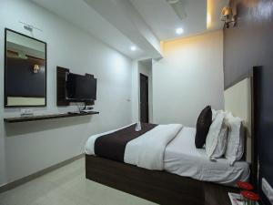 a bedroom with a large bed and a tv at OYO Hotel Dream Inn in Sarkhej