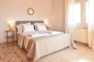 a bedroom with a large bed with white sheets and a window at Kentos Airy & Fully Equipped 3BR Family Maisonette in Chios