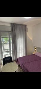 a bedroom with a purple bed and a window at MADONNA BB in Milano Marittima