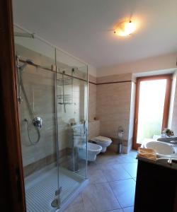 a bathroom with a glass shower and a toilet at ROOM AURORA in Fiera di Primiero