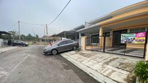 un coche aparcado en un aparcamiento al lado de un edificio en Orkid Kluang Homestay, en Keluang