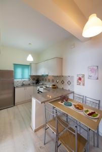 a large kitchen with a large island with chairs and a table at Meteora Suites in Nikiana +18 photos