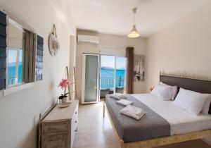 a bedroom with a bed with a view of the ocean at Meteora Suites in Nikiana