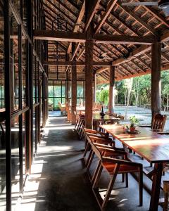 a dining area with wooden tables and chairs in a building at Ngeeb bed and EV station in Chiang Rai