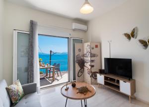 a living room with a tv and a large window at Meteora Suites in Nikiana