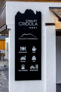 un cartello sul lato di un edificio di Chalet Cridola Dolomiti Experience a Lorenzago