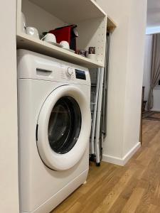 a washing machine in a laundry room with a shelf at Gemütliche Wohnung nur 15 Minuten ins Stadtzentrum in Vienna