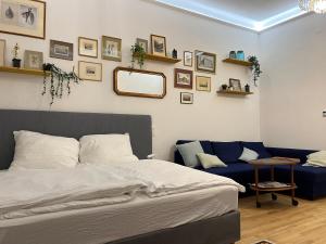 a bedroom with a bed and a blue couch at Gemütliche Wohnung nur 15 Minuten ins Stadtzentrum in Vienna