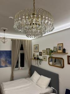 a chandelier hanging over a bed in a bedroom at Gemütliche Wohnung nur 15 Minuten ins Stadtzentrum in Vienna