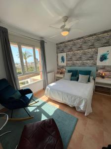 1 dormitorio con cama, silla y ventana en Apartamento de Lujo Alm. Golf Resort, Valle del Este en Vera
