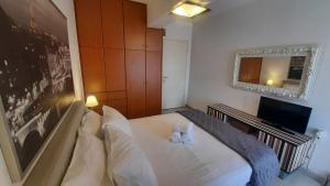 Dormitorio pequeño con cama blanca y espejo en Atsali's Apartment Xylokastro en Xylokastro