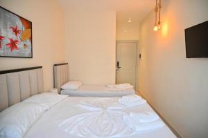 a bedroom with two beds with towels on them at Hotel Zanzi in Durrës