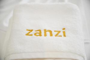 a white towel with the word zarma written on it at Hotel Zanzi in Durrës