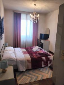 Schlafzimmer mit einem Bett und einem Kronleuchter in der Unterkunft La Grotta di San Michele in Montevettolini