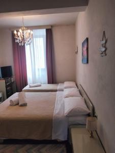 ein Hotelzimmer mit 2 Betten und einem Kronleuchter in der Unterkunft La Grotta di San Michele in Montevettolini