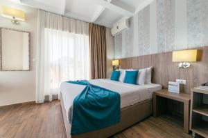 um quarto de hotel com uma cama grande com almofadas azuis em Hotel Sato em Sutomore