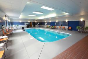 uma grande piscina numa sala com mesas e cadeiras em Holiday Inn Champaign, an IHG Hotel em Champaign