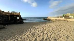 plaża z odciskami stóp w piasku i oceanie w obiekcie Zuzička Primavera w mieście Costa Del Silencio
