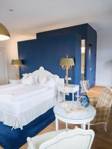ein Schlafzimmer mit einem großen weißen Bett und einer blauen Wand in der Unterkunft Hotel & Restaurant Posthalterei in Zusmarshausen